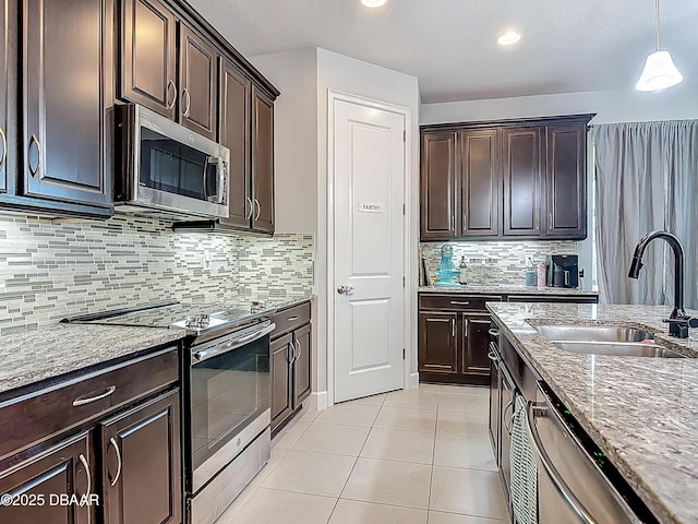 200 Azure Mist Way, Daytona Beach, FL 32124 - kitchen featuring stainless steel appliances, a sink, light stone counters, dark brown cabinetry, and light tile patterned floors