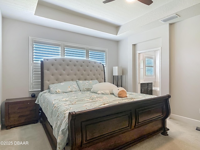 200 Azure Mist Way, Daytona Beach, FL 32124 - bedroom featuring light carpet, a tray ceiling, connected bathroom, ceiling fan, and baseboards