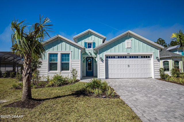 view of front of property with a garage, a front yard, and glass enclosure