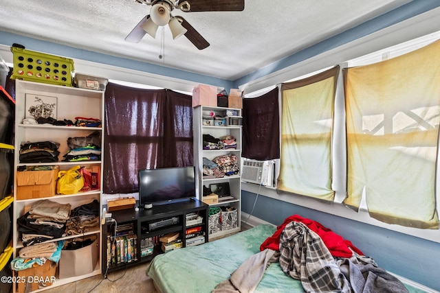 bedroom featuring cooling unit, ceiling fan, and a textured ceiling