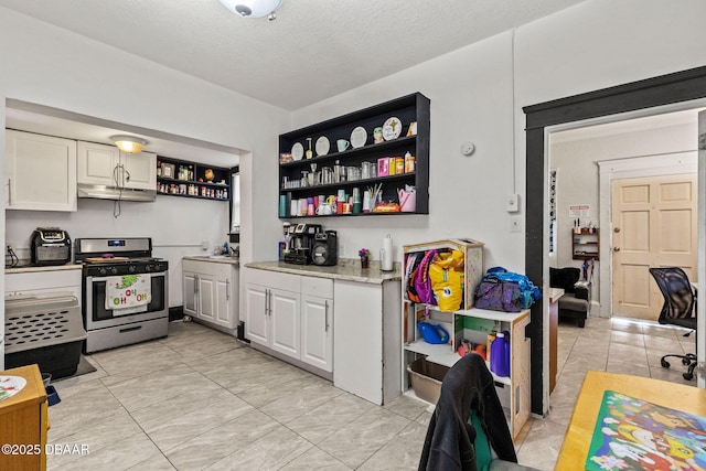 kitchen featuring a textured ceiling, stainless steel range with gas cooktop, white cabinets, and light tile patterned flooring