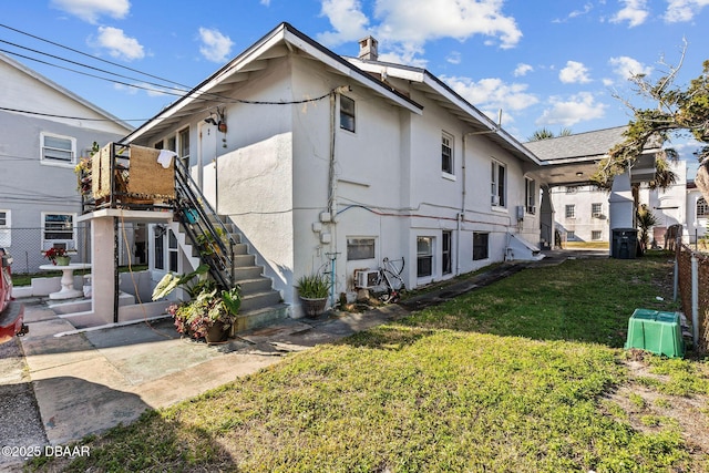 view of side of property with a patio area and a lawn