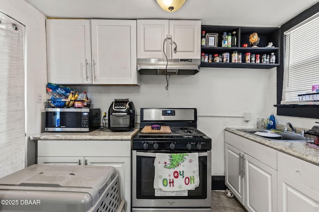 kitchen featuring appliances with stainless steel finishes, sink, white cabinets, and light stone counters