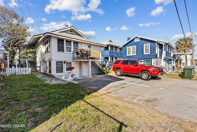 multi unit property with a balcony and a front yard