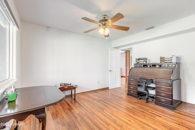 office area featuring ceiling fan, light hardwood / wood-style flooring, and a textured ceiling