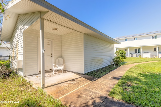 doorway to property with central AC and a yard