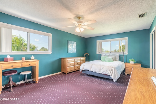 carpeted bedroom featuring ceiling fan and a textured ceiling