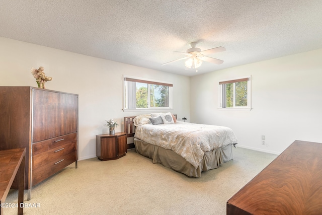 carpeted bedroom with ceiling fan, a textured ceiling, and multiple windows