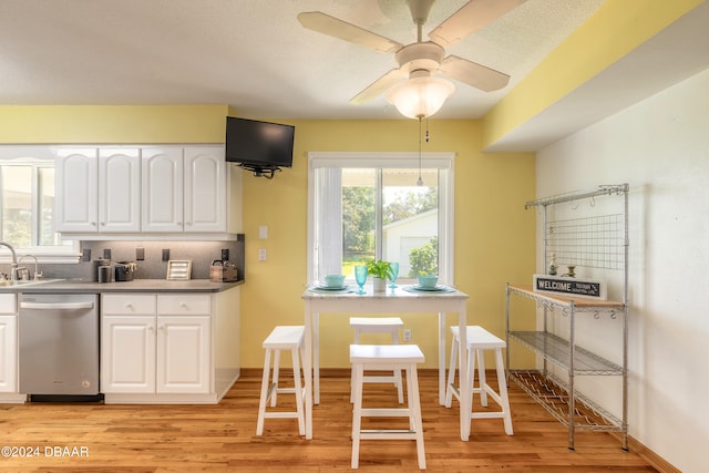 kitchen with ceiling fan, dishwasher, white cabinets, and light wood-type flooring