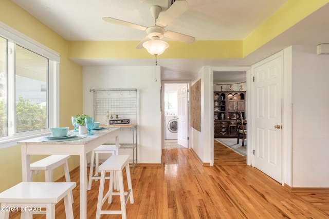 dining area with ceiling fan, a textured ceiling, washer / clothes dryer, and light hardwood / wood-style flooring