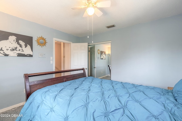 carpeted bedroom featuring a textured ceiling, a closet, and ceiling fan