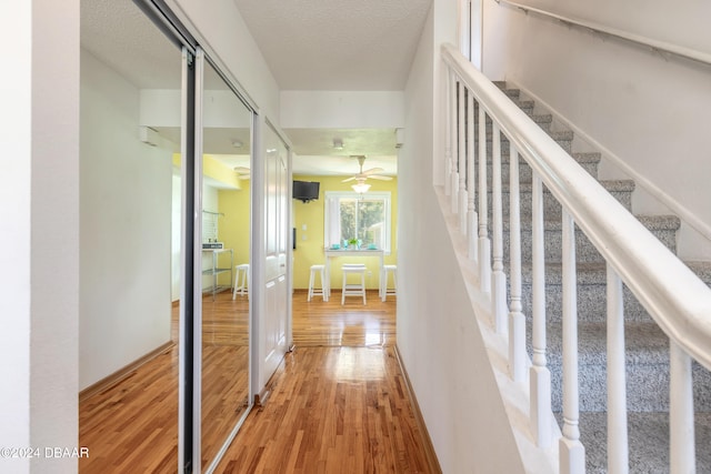 corridor with hardwood / wood-style flooring and a textured ceiling