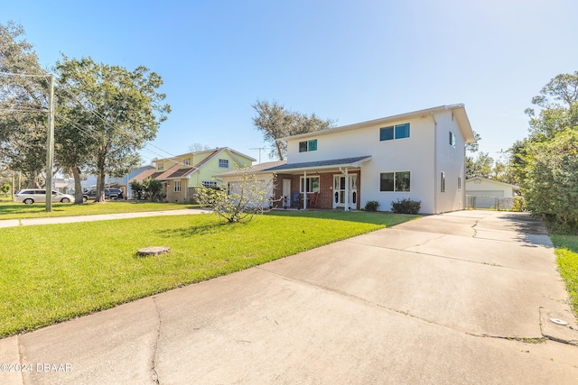 view of front of home with an outbuilding, a garage, a front lawn, and covered porch