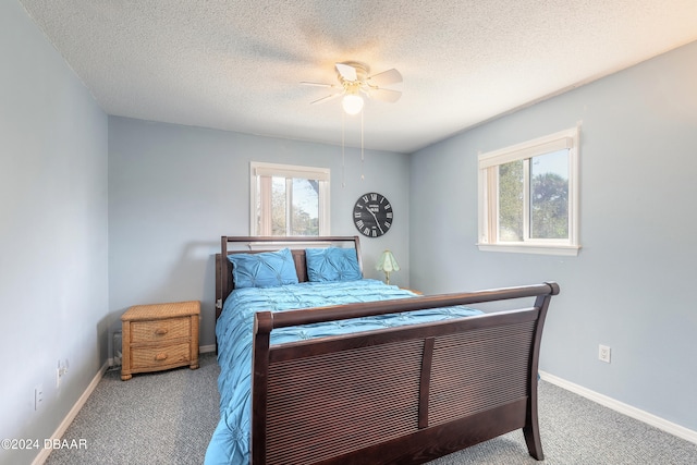 carpeted bedroom featuring a textured ceiling and ceiling fan