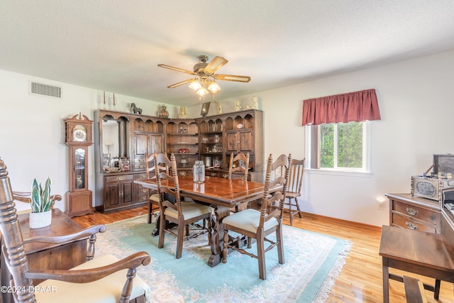 dining space featuring a textured ceiling, light wood-type flooring, and ceiling fan