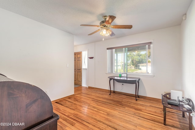 interior space featuring ceiling fan, light hardwood / wood-style flooring, and a textured ceiling