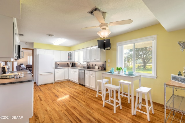 kitchen featuring appliances with stainless steel finishes, a textured ceiling, ceiling fan, light hardwood / wood-style floors, and white cabinetry