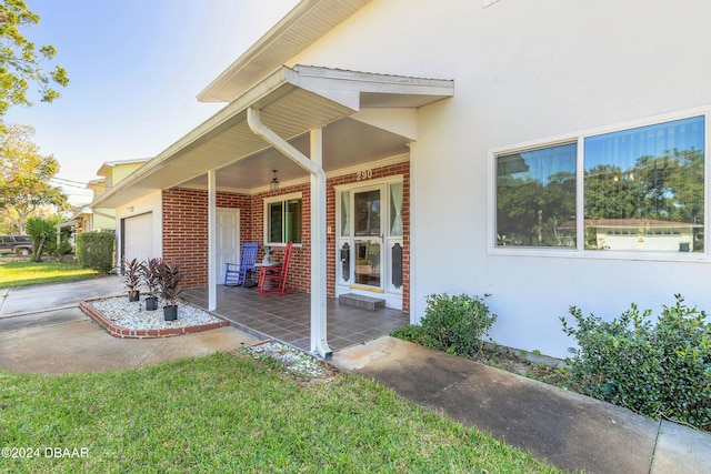 view of exterior entry with a porch and a garage