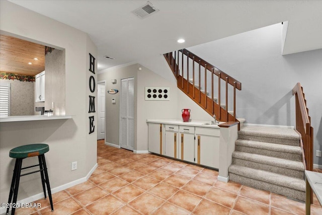 140 Limewood Pl Unit 3, Ormond Beach, FL 32174 - kitchen with a breakfast bar area, baseboards, recessed lighting, light countertops, and white cabinetry