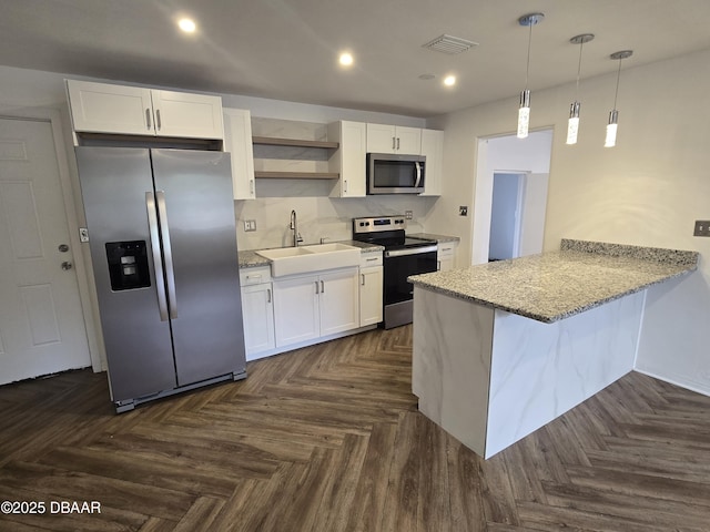 kitchen featuring stainless steel appliances, kitchen peninsula, sink, and white cabinets