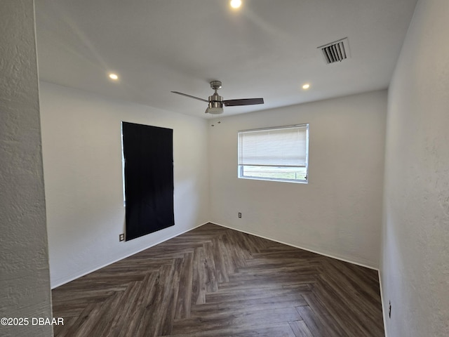 unfurnished room featuring dark parquet flooring and ceiling fan