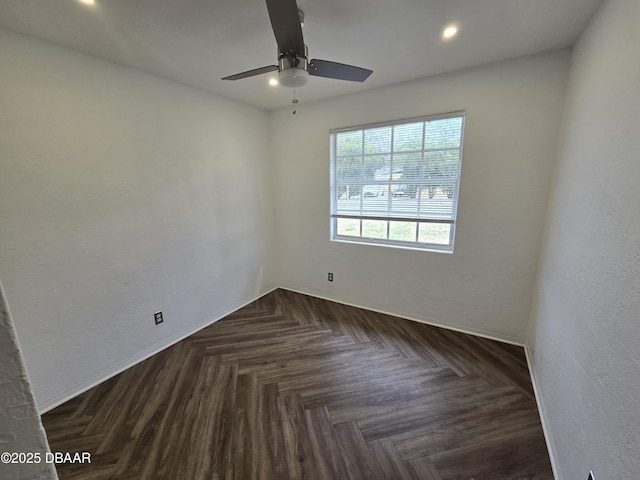 empty room featuring ceiling fan and dark parquet flooring