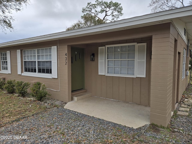 view of exterior entry with a patio area