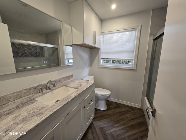 full bathroom featuring shower / bath combination with glass door, parquet flooring, vanity, and toilet