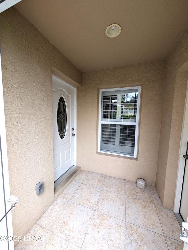 property entrance with a patio and stucco siding