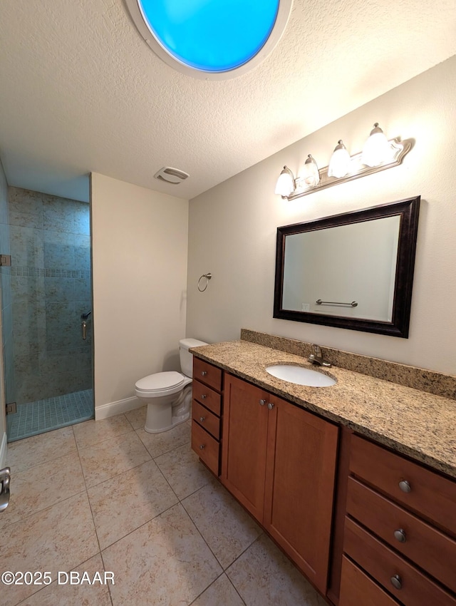 bathroom featuring a textured ceiling, tile patterned flooring, a shower stall, and vanity