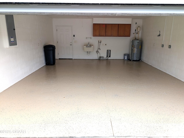 garage featuring concrete block wall, a sink, electric water heater, and electric panel