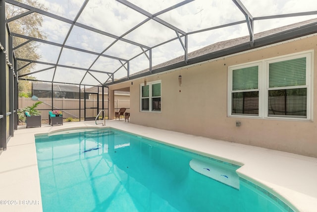 view of pool with glass enclosure, a fenced in pool, a patio area, and fence