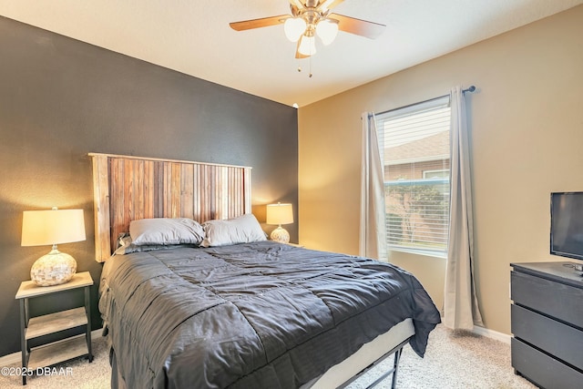 carpeted bedroom featuring baseboards and a ceiling fan