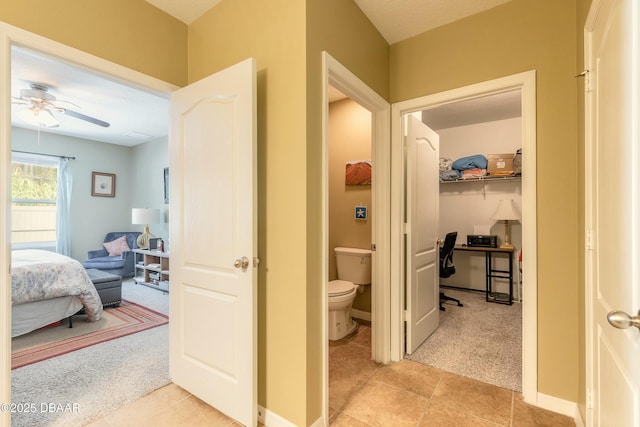 corridor with light tile patterned flooring, light colored carpet, and baseboards