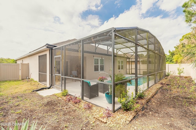 back of house with a patio area, a fenced backyard, a fenced in pool, and a lanai