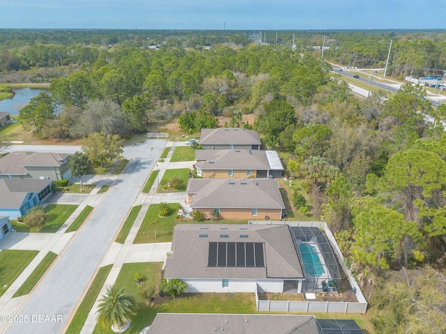 birds eye view of property with a wooded view and a water view