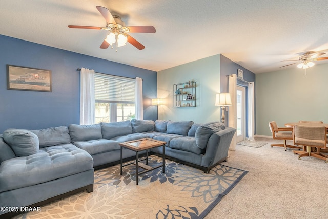 carpeted living room featuring a ceiling fan, baseboards, and a textured ceiling