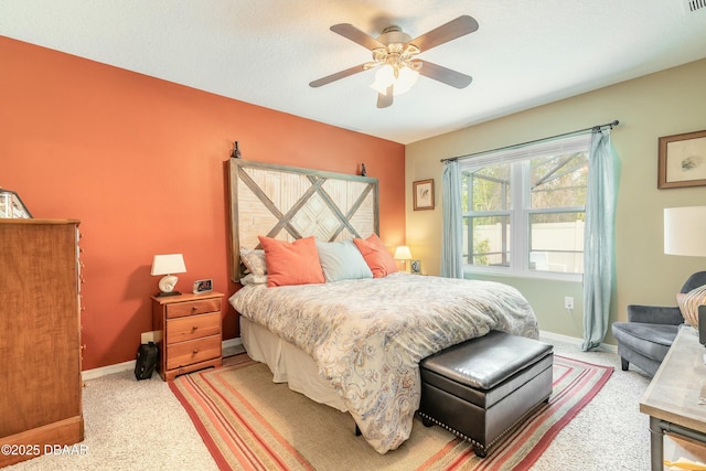 bedroom with light colored carpet, a ceiling fan, and baseboards