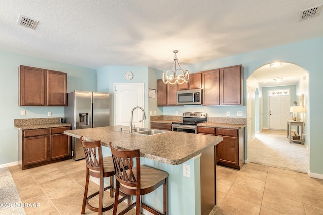 kitchen with arched walkways, visible vents, appliances with stainless steel finishes, and a sink