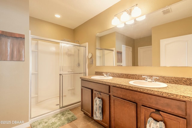 bathroom featuring a sink, visible vents, a shower stall, and tile patterned floors