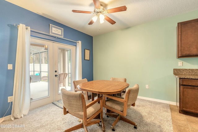 dining space featuring a textured ceiling, french doors, a ceiling fan, and baseboards