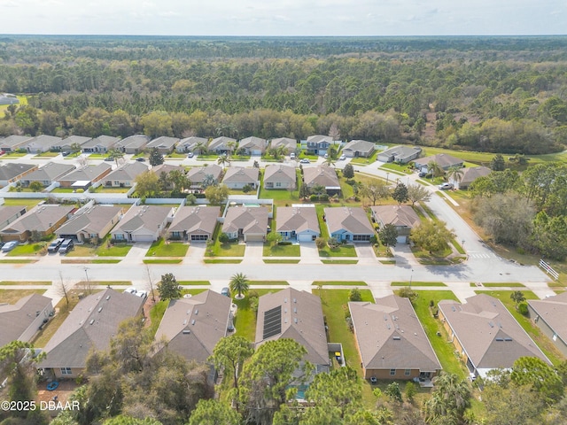 drone / aerial view with a forest view and a residential view