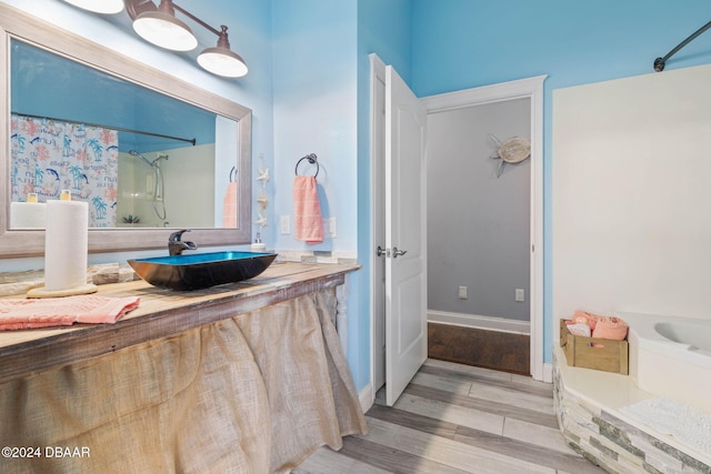 bathroom with wood-type flooring, vanity, and walk in shower