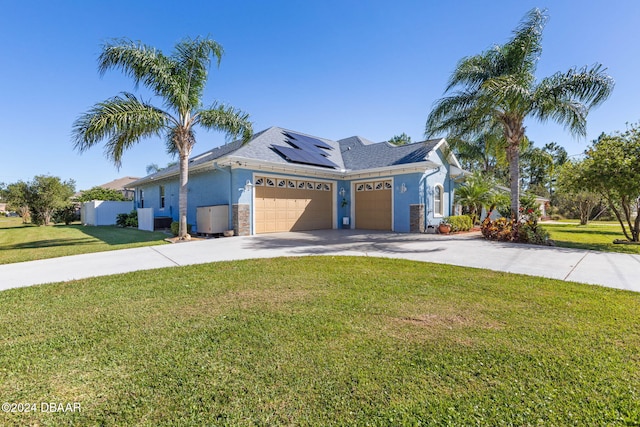 view of front of home featuring a front lawn, a garage, and solar panels