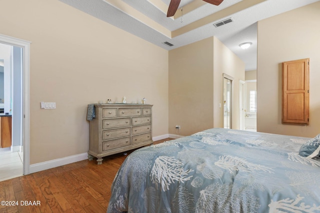 bedroom with a textured ceiling, light hardwood / wood-style flooring, ensuite bath, and ceiling fan