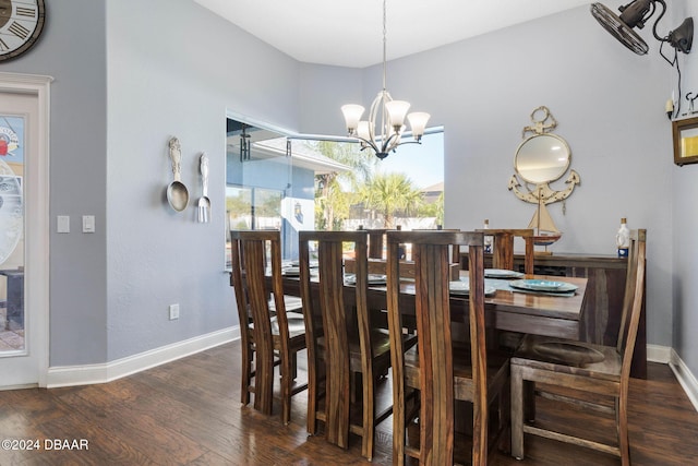 dining space with dark hardwood / wood-style flooring and an inviting chandelier