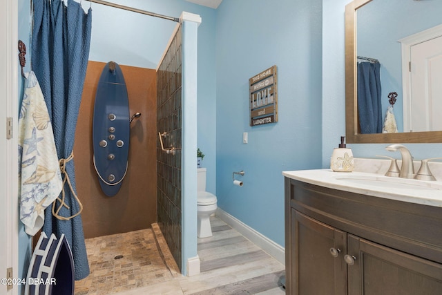 bathroom with vanity, toilet, wood-type flooring, and walk in shower