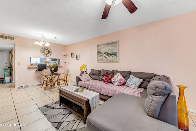 tiled living room with ceiling fan with notable chandelier and a textured ceiling