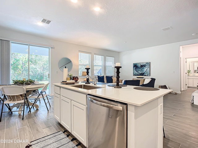 kitchen with dishwasher, sink, light hardwood / wood-style flooring, an island with sink, and white cabinetry