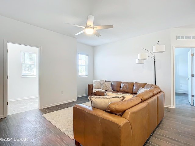 living room featuring ceiling fan and dark hardwood / wood-style floors